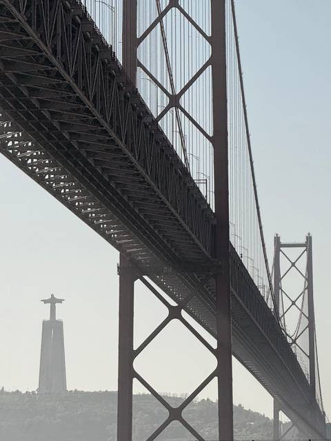 Bridge with a large statue in the background.