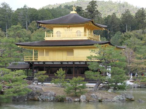 Golden pavilion surrounded by trees and a small pond.