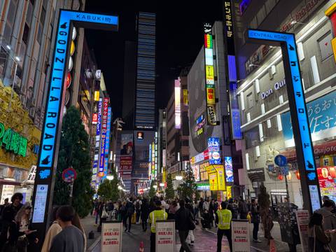 Busy street in a city with bright neon lights at night.