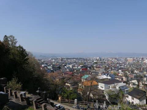 Panoramic view of a city with distant snowy mountains.