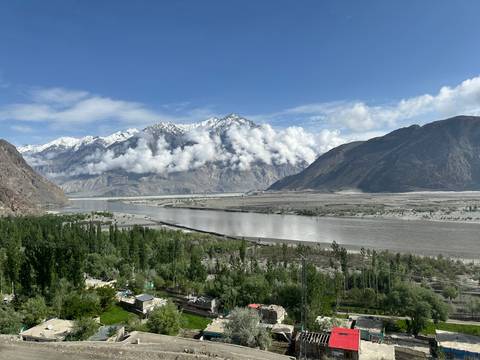 Large river with mountains and clouds in the background.