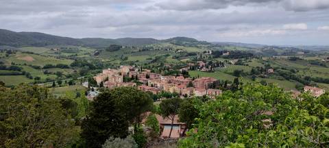 A scenic view of a village surrounded by hills.