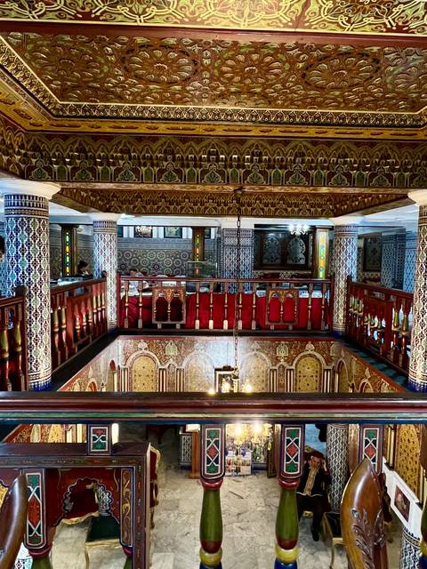 Interior with ornate woodwork and colorful tiles.