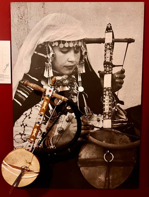 Historical photograph of a person with musical instruments.