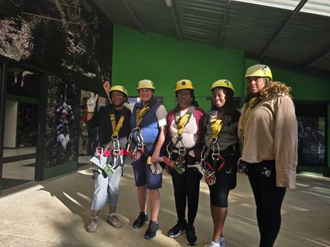 Group of people wearing harnesses posing for a photo.