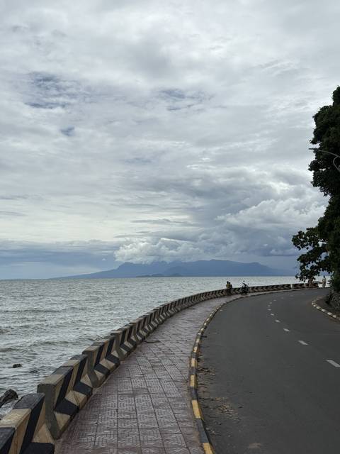 A scenic coastal road with mountains in the background.