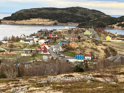 Colorful seaside village with vibrant houses and surrounding water.