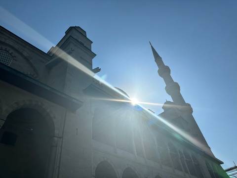 Mosque silhouette with sun rays.