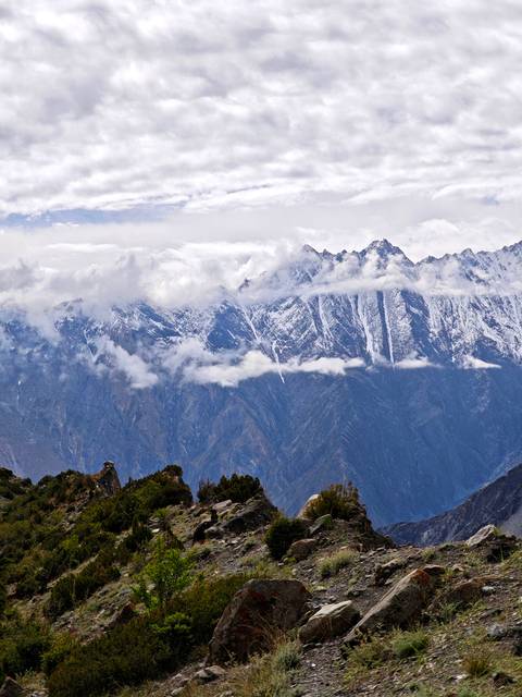 Snow-capped mountains with clouds over them.