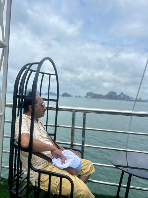 Person sitting on a boat with scenic views of limestone islands.