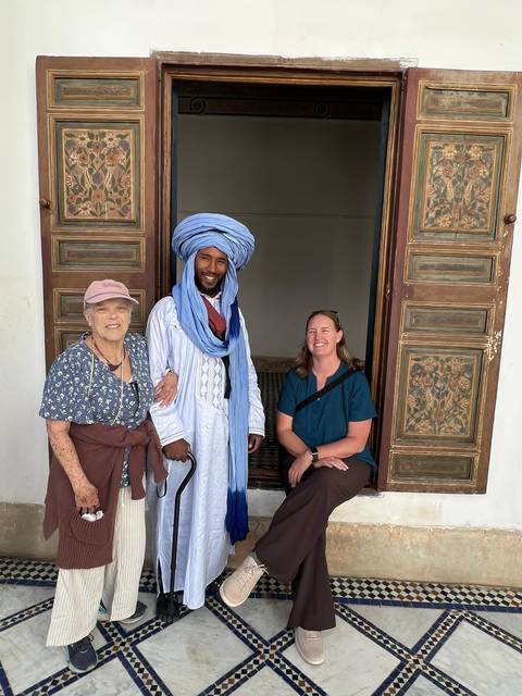 Tourists posing with a local in traditional attire.