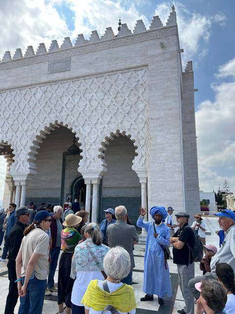 Group of tourists outside a mosque with intricate architecture.