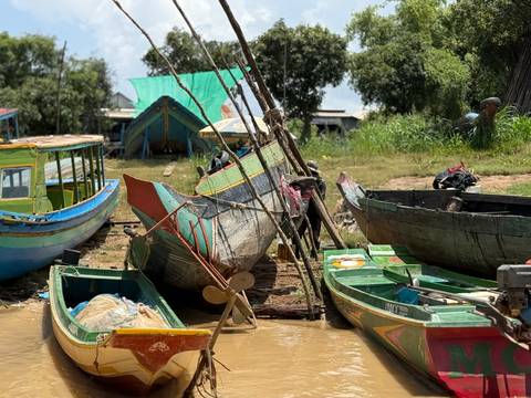 Colorful boats on the shore near a water body.
