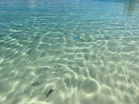 Clear water showing sandy sea floor.