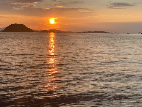 Beautiful sunset over the ocean with silhouette of land.