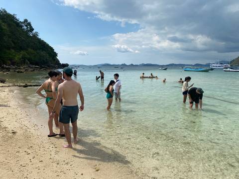 Group of people enjoying the beach in shallow water.
