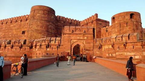 Visitors walking in front of the historic Agra Fort.