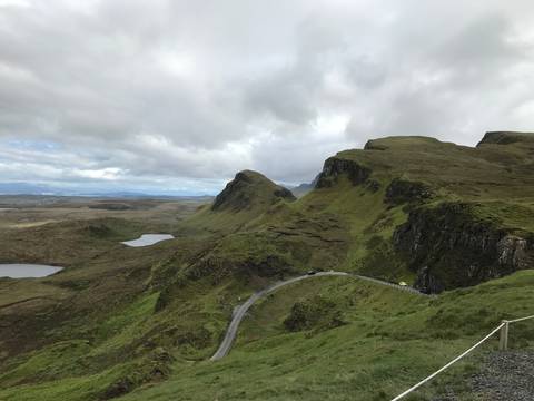 Vast rolling hills with cloudy skies and a winding road.