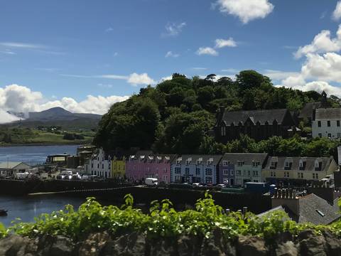 Colorful buildings along the waterfront with a hill in the background.