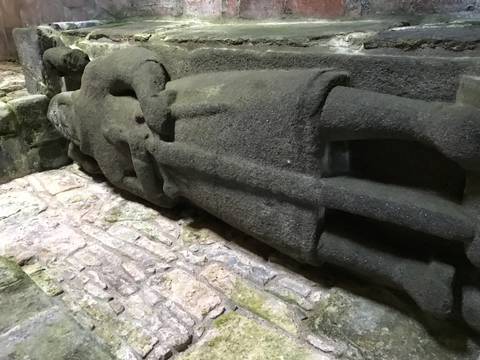 Stone statue of a knight lying on the ground.