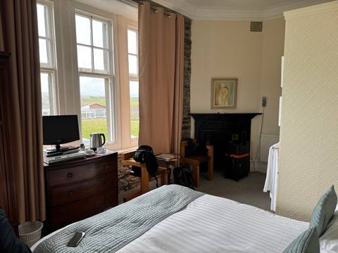 Interior of a hotel room with a view of the countryside.