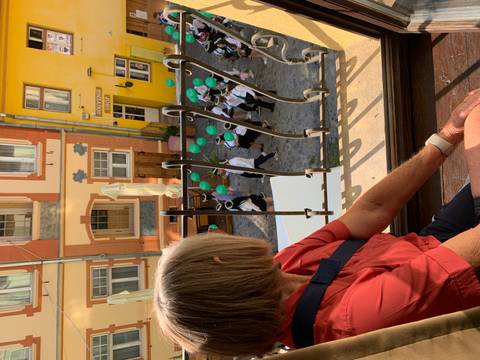 Person looking out of a window at a street parade