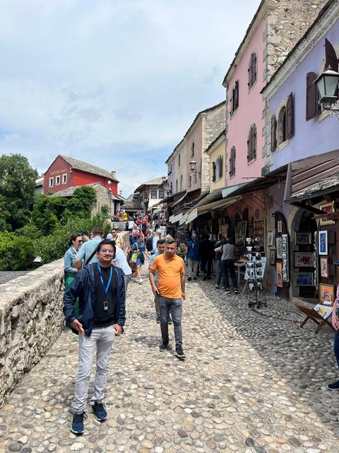 Market street with people exploring shops and souvenirs.