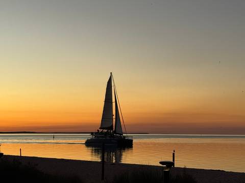 Sailing boat at sunset on a calm sea.