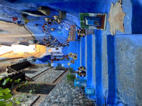 A vibrant blue alleyway with colorful decorations and art pieces.