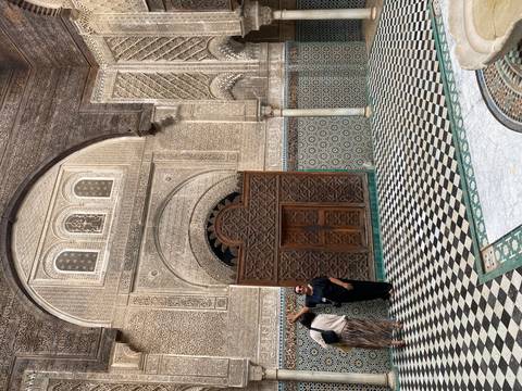 An ornate entrance with detailed mosaic work and a wooden door.