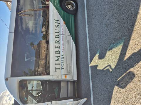 Bus with 'Timberbush Tours' branding parked on a road.