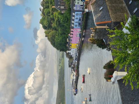Colorful waterfront buildings and boats by a harbor.