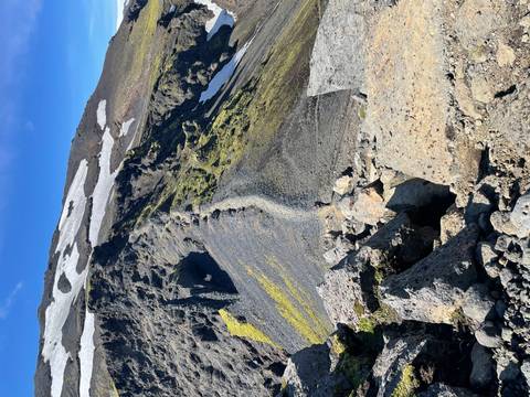 A rocky mountain ridge with patches of snow.