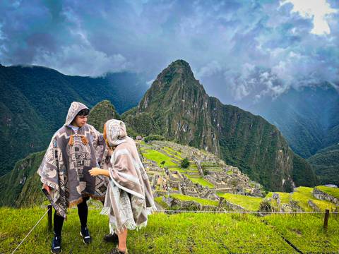 People in traditional clothing with Machu Picchu in the background.