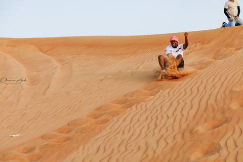 Person sliding down a sand dune.