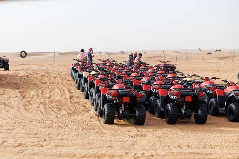Line of red ATVs in the desert.