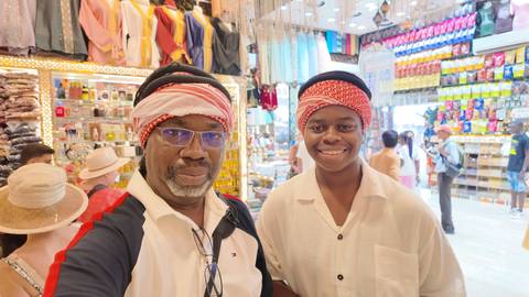 Two people wearing headscarves in a colorful shop.