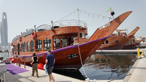 People boarding a traditional wooden boat at the marina.