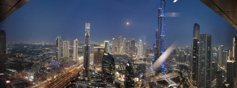 Panoramic night view of a city's skyscrapers.
