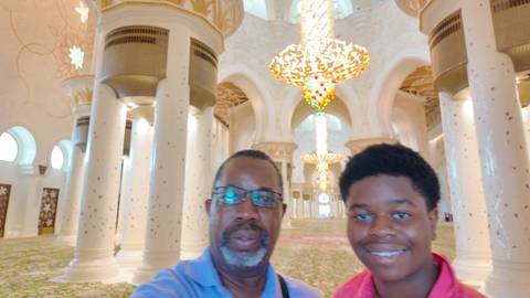 Two people inside a grand mosque.