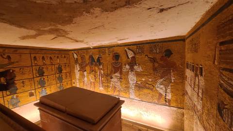 Interior of an ancient Egyptian tomb with murals.
