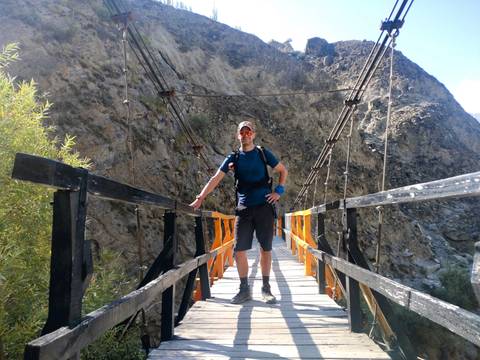 Person standing on a bridge in a mountainous area