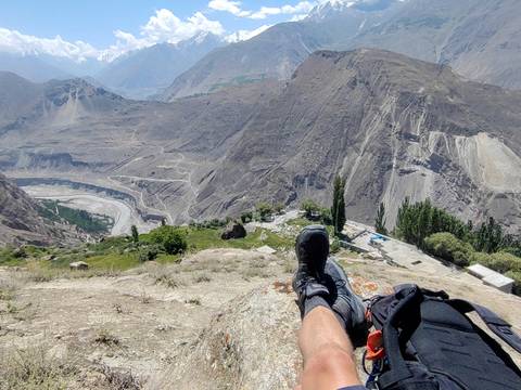 Scenic mountain view with a person’s feet in the foreground.