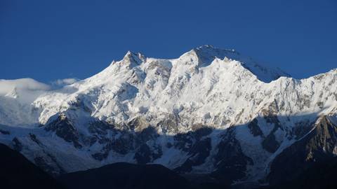 Snow-covered mountain peak under a blue sky.