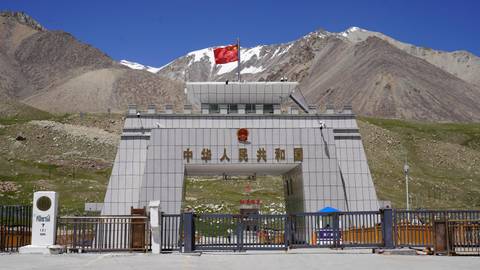 Chinese border gate with mountains in the background.