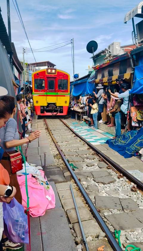 Train passing through a bustling market area.