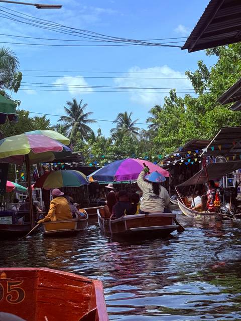 Floating market with colorful umbrellas and boats.