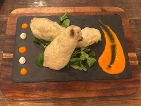 Plated dish with decorative sauces and greens.