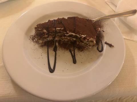 Dessert on a plate drizzled with chocolate sauce.