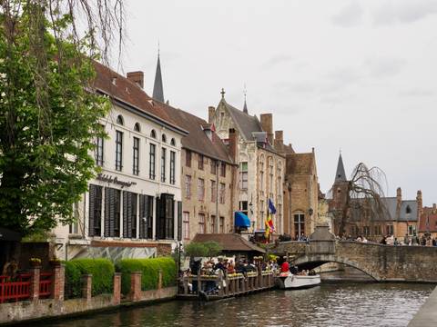Charming canal view of historic buildings with flags in Europe.